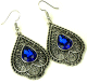Boucles d'oreilles pendantes en metal argente cisele serties de pierres bleu roi