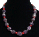 Collier ethnique artisanal imitation pierres marbrees mauves agrementees de perles argentees, rouges et en bois