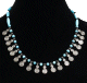 Collier ethnique artisanal imitation perles turquoises et noires agencees derriere par des perles en tube et agremente de petites breloques spirale en metal argente
