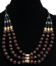 Collier ethnique artisanal imitation boules marrons gravees agrementees de perles jaunes, d'armatures argentees et de tubes noirs