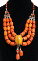 Collier ethnique artisanal imitation corail orange agremente assorti de perles et d'agrements en metal avec un gros pendentif jaune