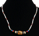 Collier ethnique artisanal imitation perles multicolores agrementees d'une pierre cylindree au milieu