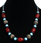 Collier ethnique artisanal imitation pierres rouges agrementees de perles bleues claires, noires et d'armatures argentees
