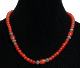 Collier ethnique artisanal imitation perles rouges agrementees d'autres perles en metal