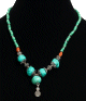 Collier ethnique artisanal imitation perles vertes, des pierres turquoises agremente d'un pendentif tourbillon