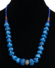 Collier ethnique artisanal imitation pierres bleues agrementees de perles en metal, bleues et d'autres en bois avec un pendentif en metal