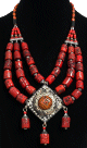 Collier ethnique berbere imitation corail agence de perles et agremente d'un gros pendentif, de breloques et d'armatures en metal argente