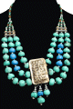 Collier ethnique berbere imitation pierres turquoises agence de perles et agremente d'un gros pendentif en metal dore, de breloques et d'armatures gravees en metal argente