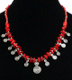 Collier artisanal imitation pieces rouges corail agencees de perles rouges, argentees et agremente de pendentifs tourbillon en metal argente