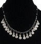 Collier ethnique artisanal perles noires et autres argentees, agremente de petits pendentifs spirale en metal argente