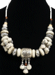 Magnifique collier ethnique artisanal imitation pierres blanches, agencees d'armatures et de perles et agremente d'une grosse boule argentee gravee et de breloques