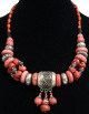 Magnifique collier ethnique artisanal imitation pierres rouges, agencees d'armatures et de perles et agremente de breloques d'une grosse boule argentee gravee