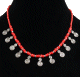 Collier ethnique imitation perles rouges corail agencees de perles argentees agremente de petits pendentifs tourbillon spirale en metal argente