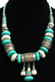Collier ethnique imitation pierres turquoises, blanches avec de gros agrements argentes joliment ciseles et breloques