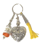 Porte-cles artisanal grand coeur et breloques en metal argente cisele et pompon en sabra jaune